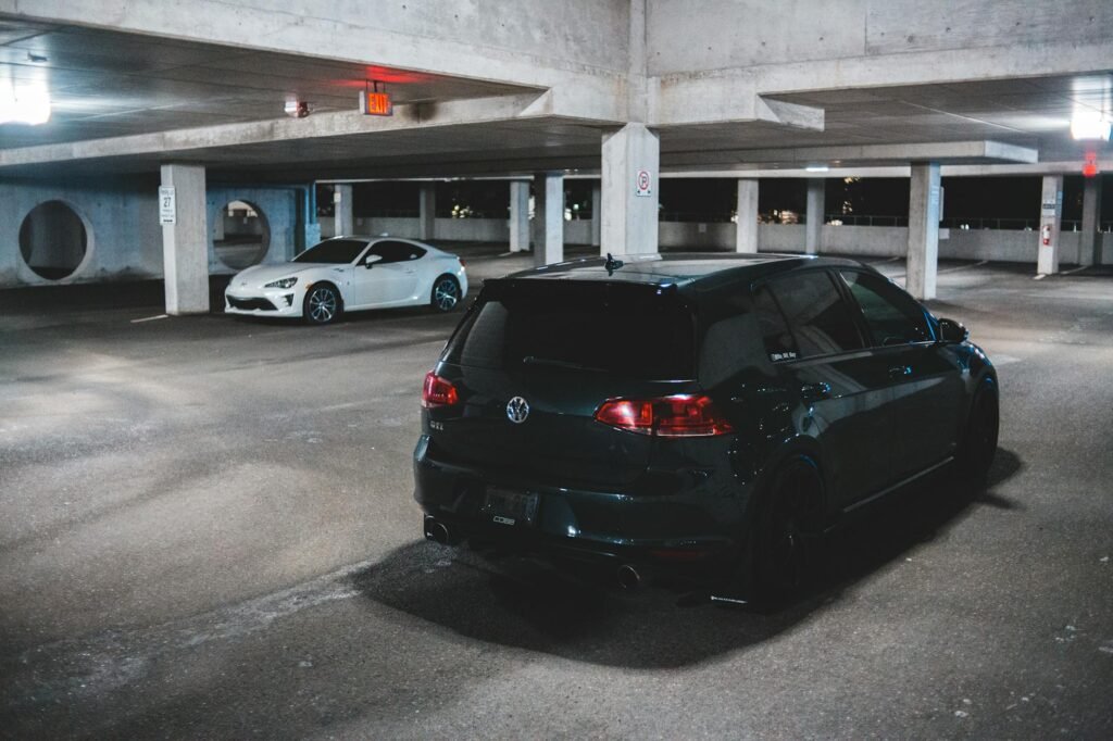 Contemporary prestige automobile parked on asphalt ground lighted with bright shiny lamps